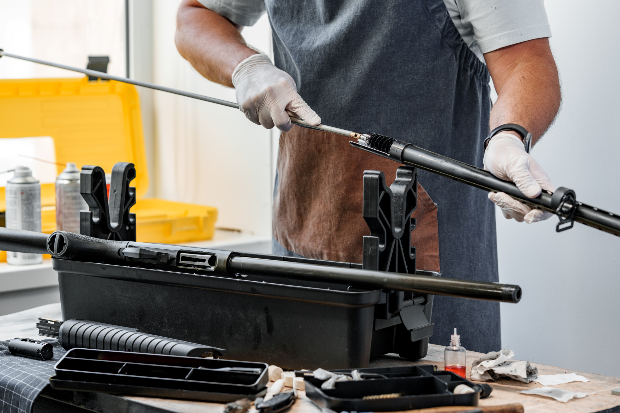 Hunter maintaining a rifle with cleaning tools — Field Tips & Care category banner for Fieldborne Gear.